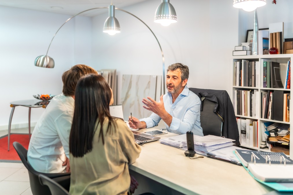 Un couple en pleine discussion avec son conseiller financier pour établir un bilan patrimonial.