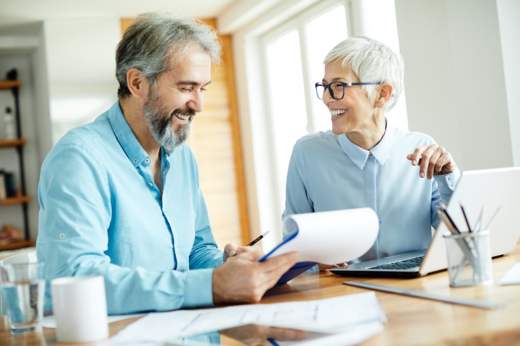 Un conseiller financier accompagnant un couple de seniors dans la préparation de leur retraite.